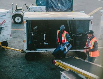 airline workers unload luggage