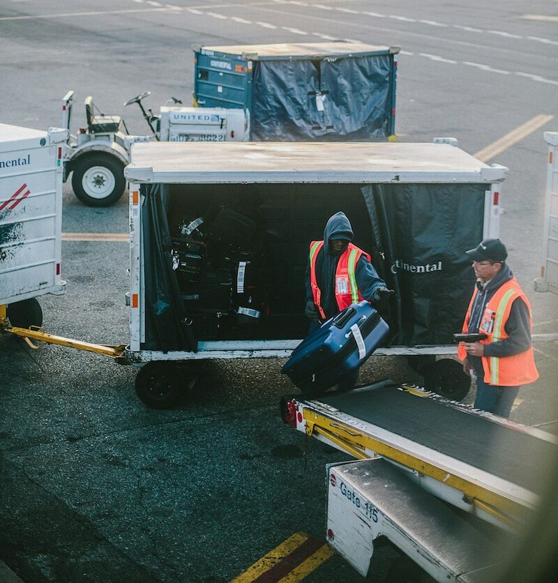 airline workers unload luggage