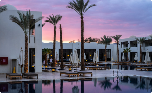 sunset behind a modern hotel pool