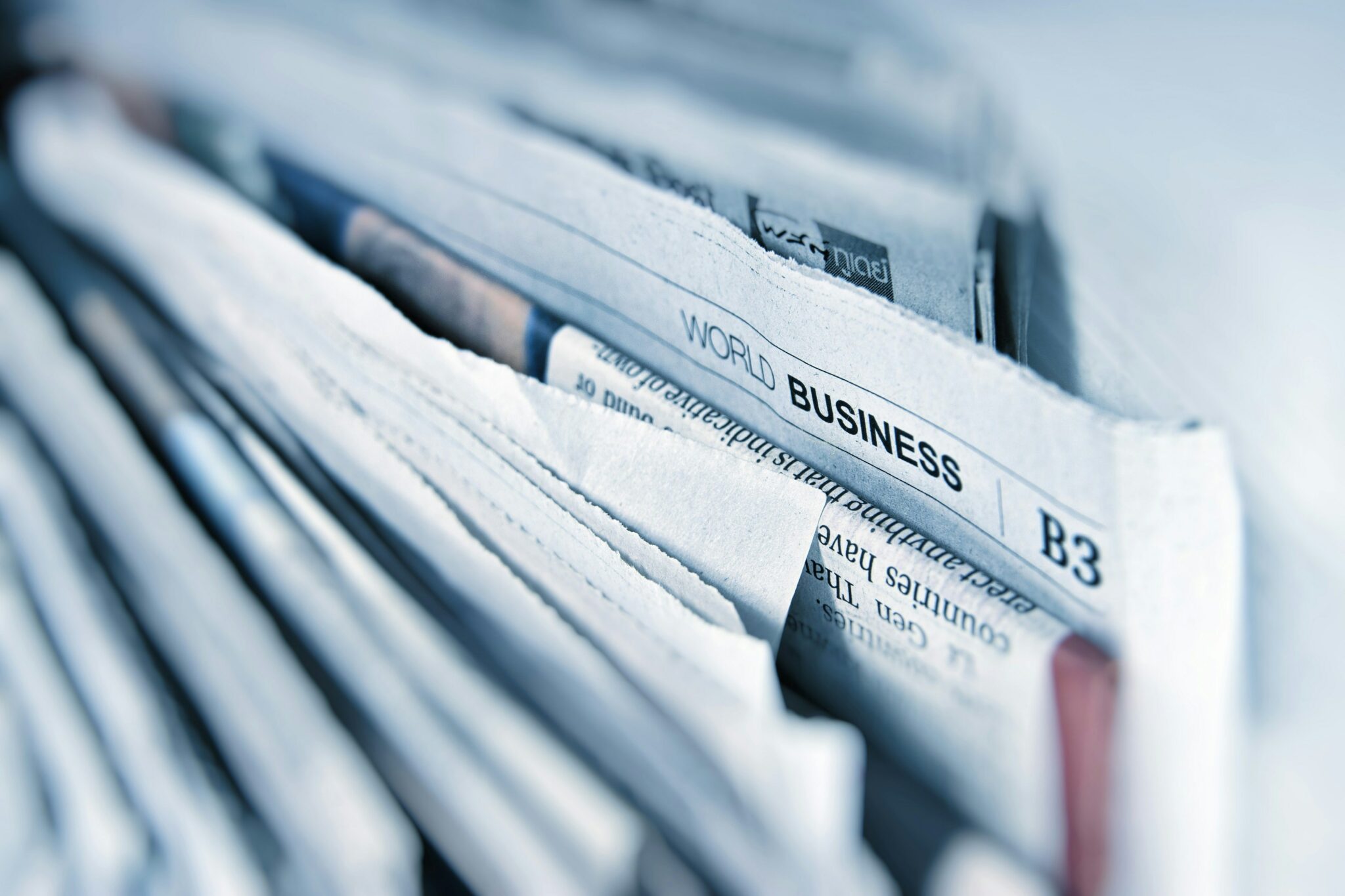 Close-up of a stack of newspapers with a focus on the section labeled "World Business.