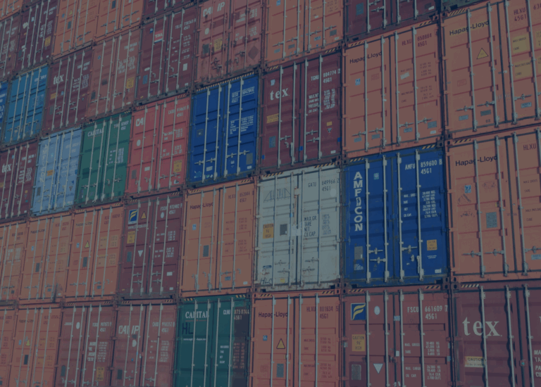 Stacked shipping containers in various colors are arranged in neat rows, creating a colorful and orderly pattern at a shipping yard—a lively scene influenced by shifting interest rates affecting global trade.